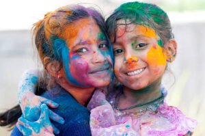 "Holi Festival 2025 celebration with people joyfully throwing colors in the air during the vibrant festival."